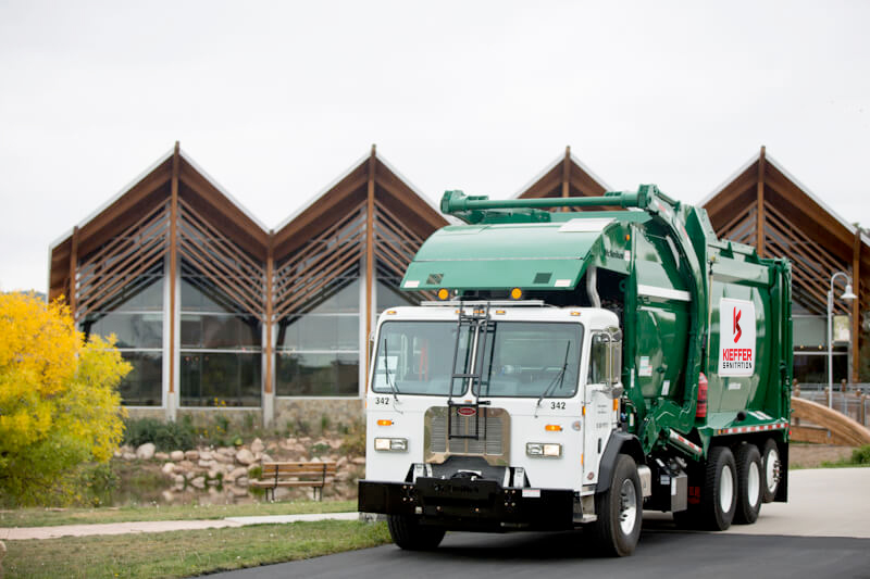 Photo of Kieffer Sanitation residential truck in front of building.