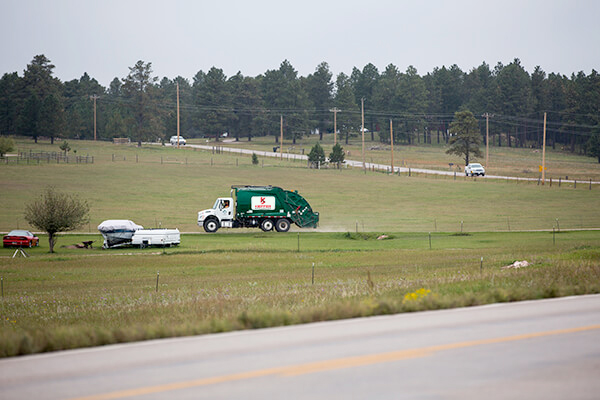 Photo of Kieffer Sanitation truck driving down gravel road.