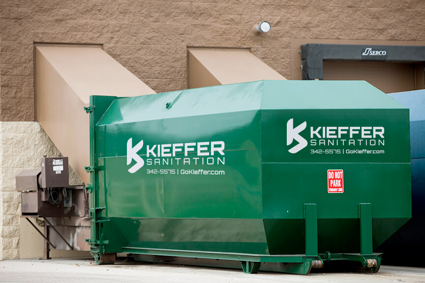 Image of Commercial Compactor placed by building.