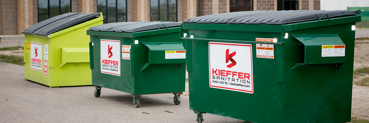 Photo of three commercial garbage bins; a 4-yard slope bin and two 2-yard standard bins from Kieffer Sanitation.