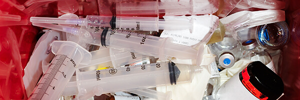 Photo of several syringes in puncture resistant container.