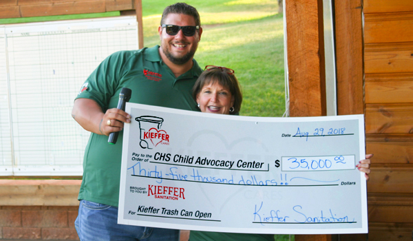 Kieffer employee holding up $35,000 check raised for CHS Child Advocacy Center.